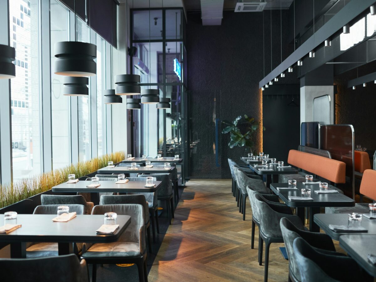 Rows of restaurant tables and chairs in gray room