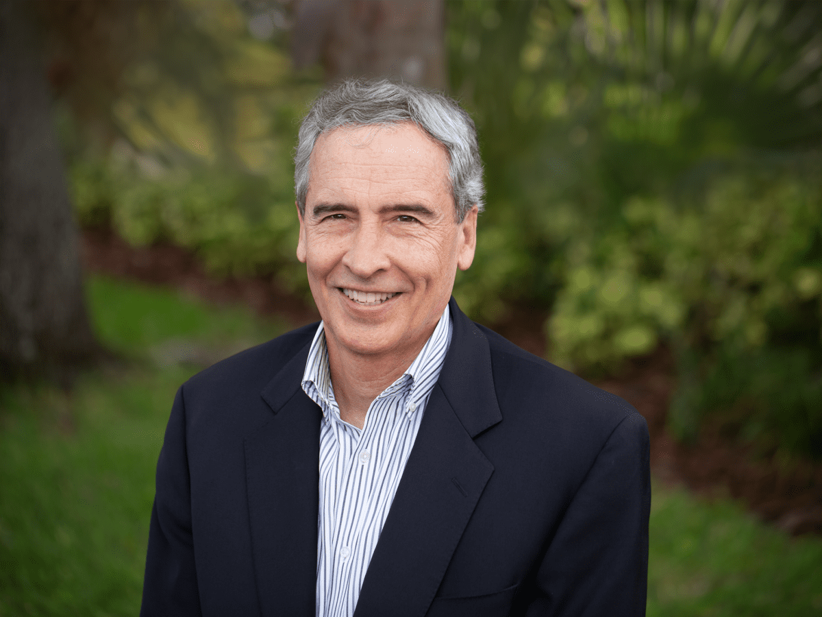 smiling gray-haired man in navy blazer
