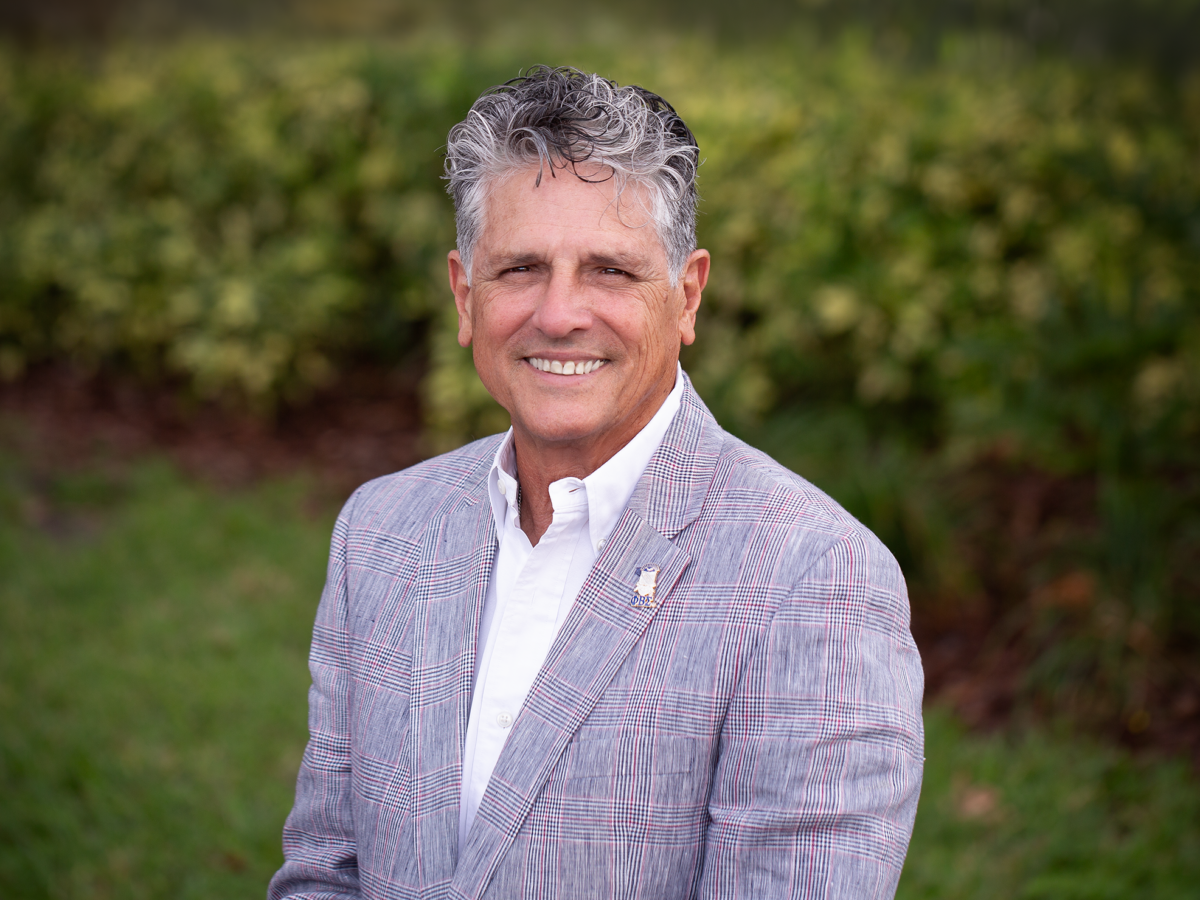 A man in a suit and tie standing outside.