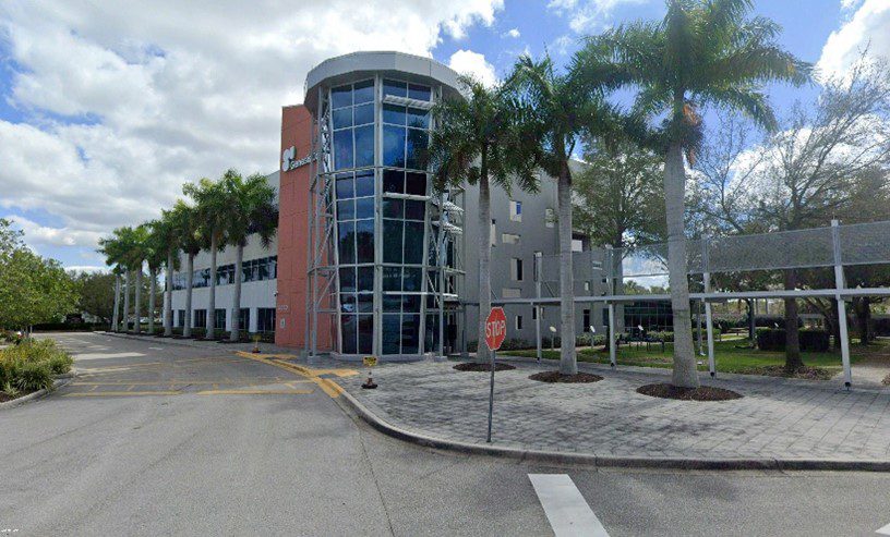 A building with palm trees in front of it.