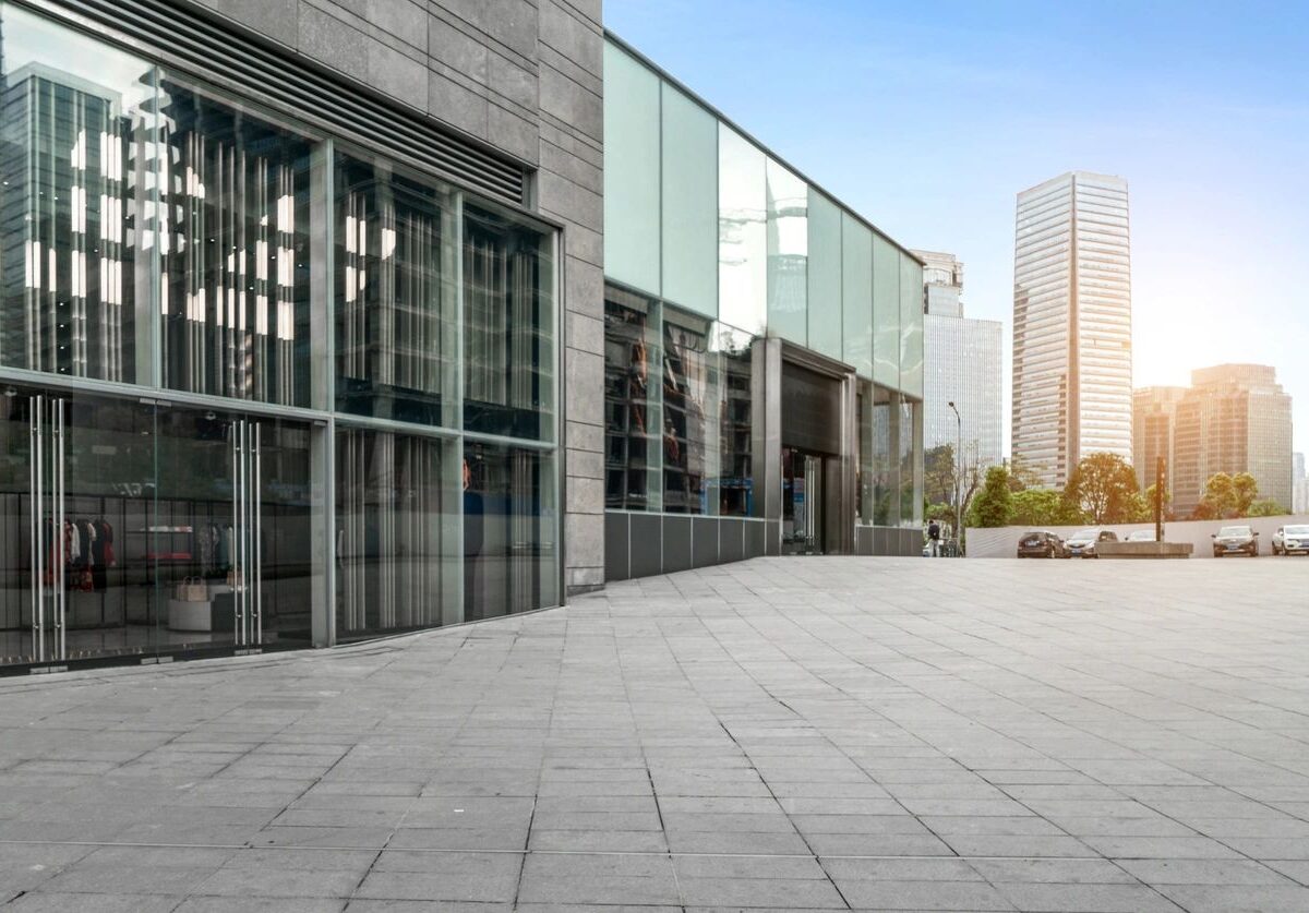 Sunlit urban plaza beside a modern glass building