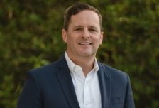 Smiling man in navy blazer outdoors