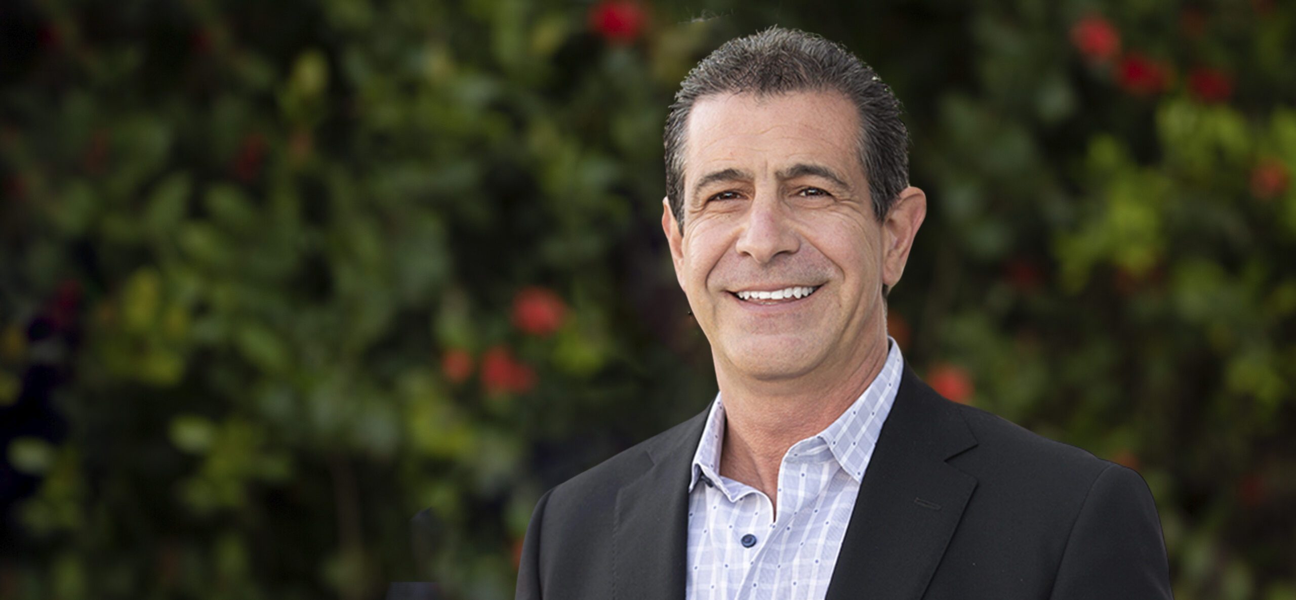 Smiling middle-aged man in blazer outdoors