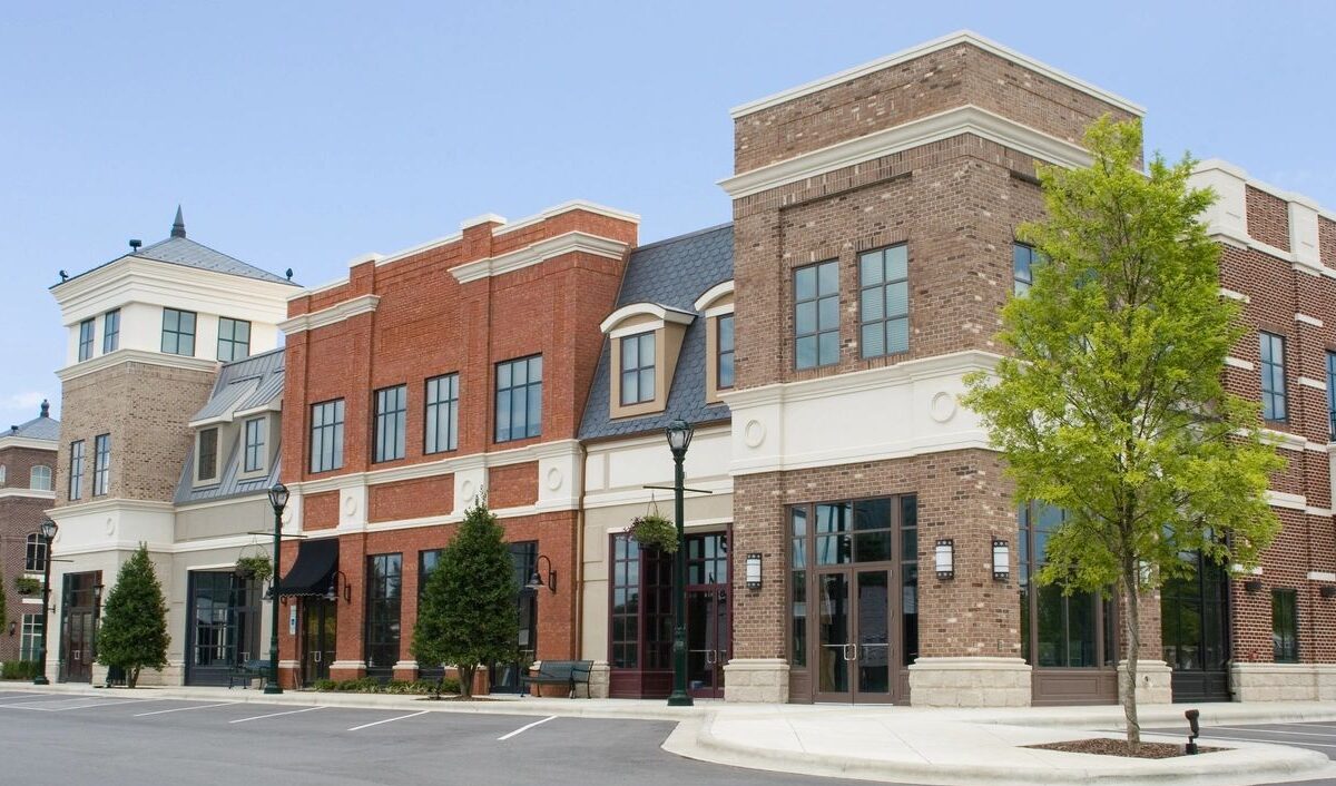 Empty suburban brick storefronts under blue sky