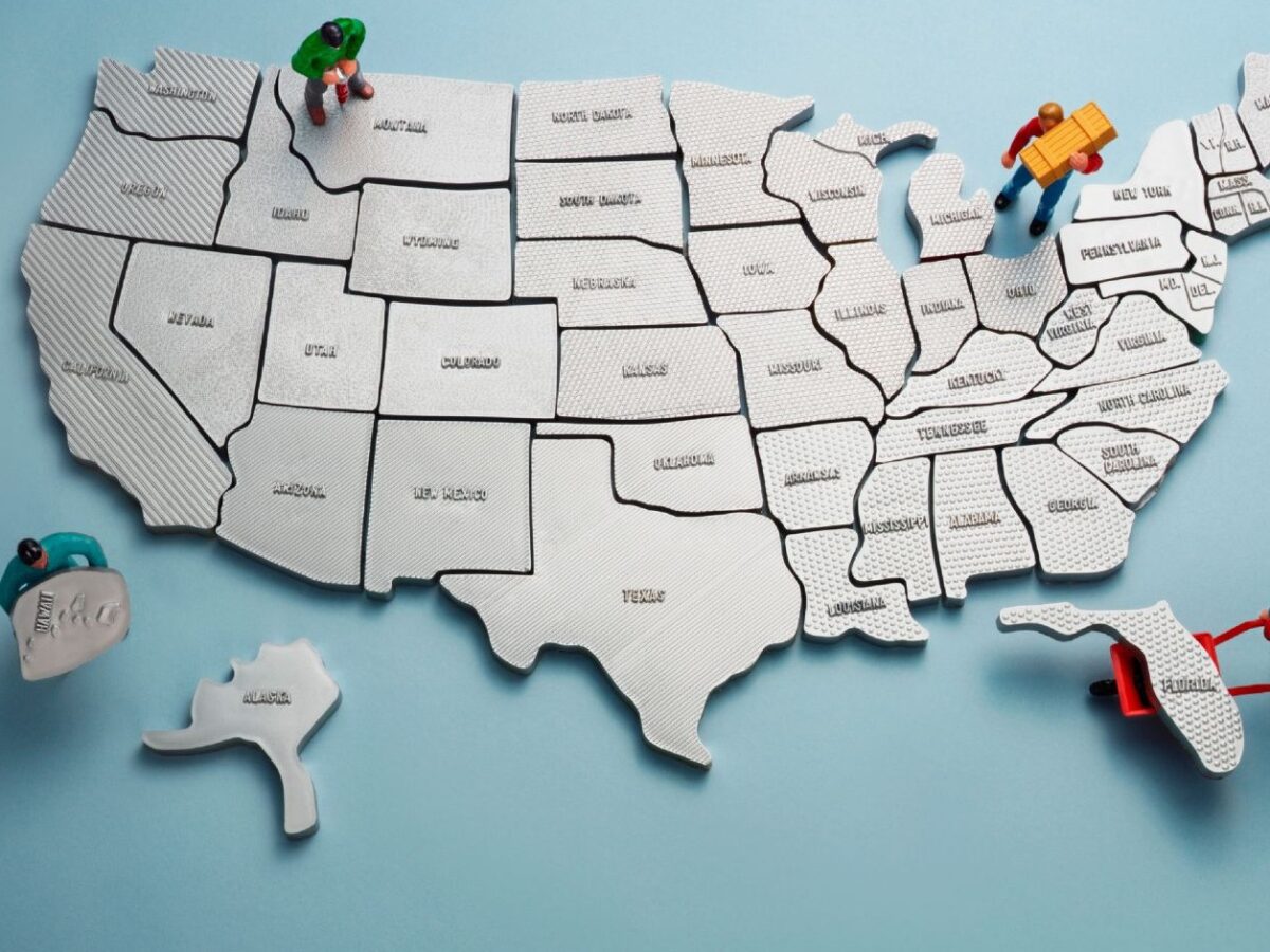 Miniature workers assembling US puzzle map