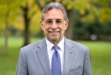 Smiling man in gray suit outdoors